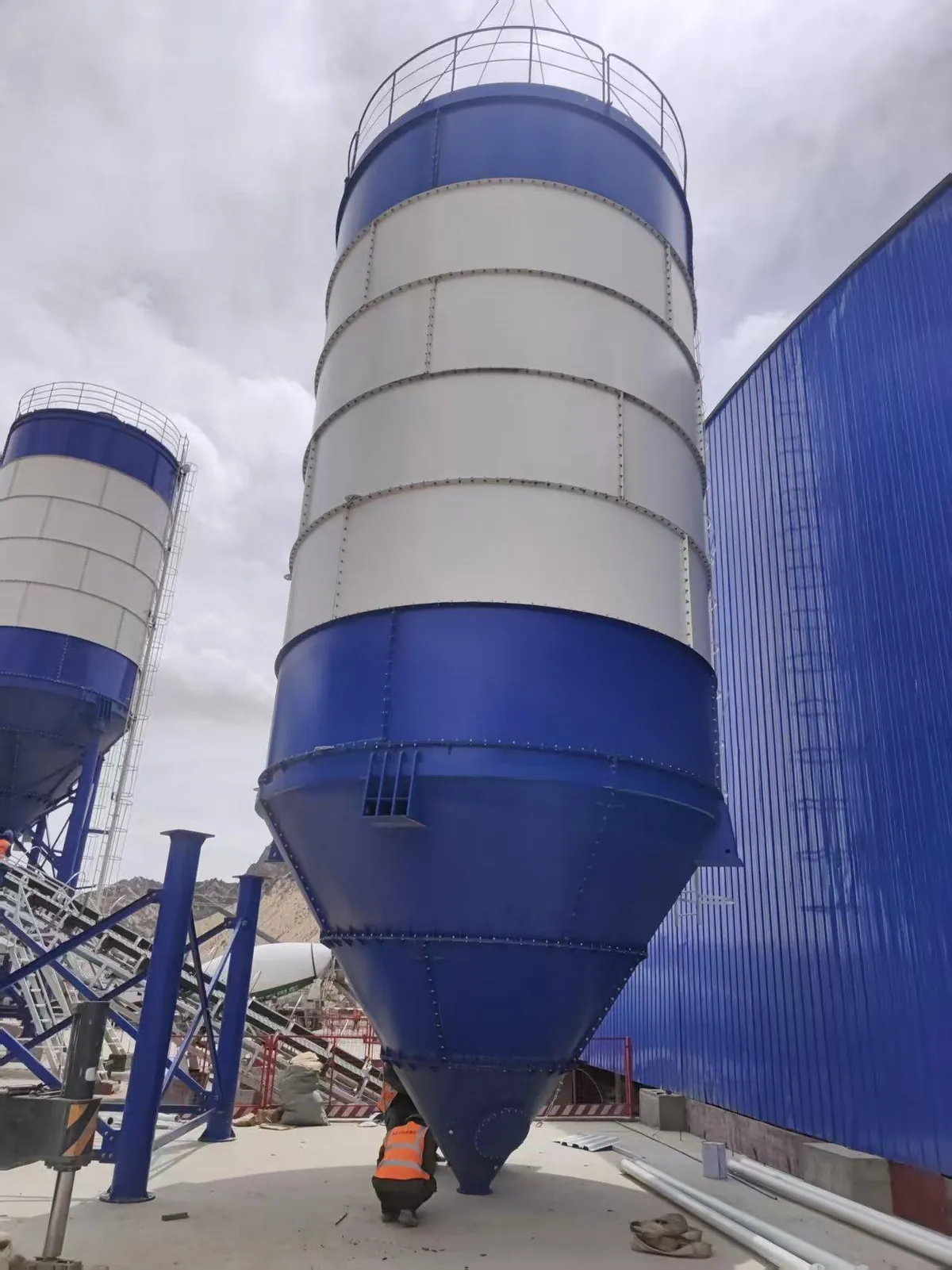 Bolted cement silo with modular wall panels and conical discharge